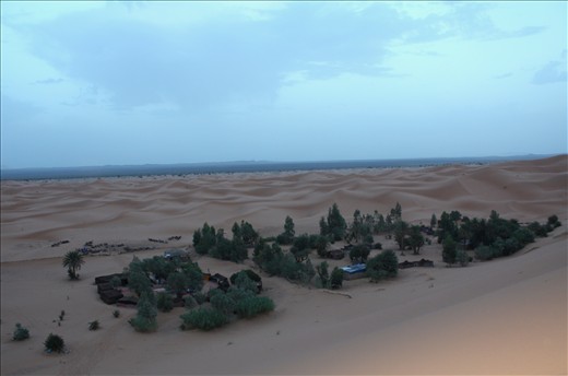 By the time the group reaches the camp, the sun is beginning to set. A large dune is the perfect place to see the sunset and get a bird's eye view of the Berber camp where the group will spend the night.