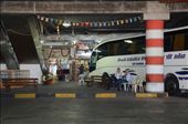 Two bus drivers sit waiting in the coach park for their tourists to return. The hanging flags from the buildings ceiling is representative of the different nationalities that visit every year whilst in the back ground a shop keeper sits awaiting custom. He sells tourist mementos of religious depictions along with postcards. Tourism is a vast source of income for the country.: by sarahg, Views[213]