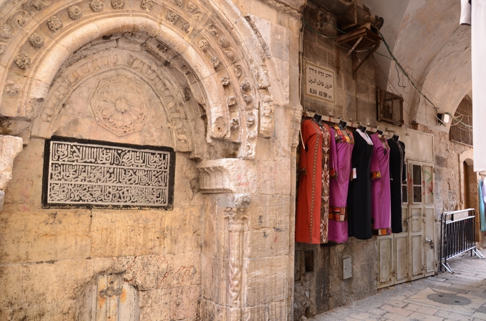 Dresses hang on the wall of a market in the centre of Jerusalems old city. The vibrant colours and patterns of the arabesque clothing nods towards modernity whilst the shape retains tradition. 