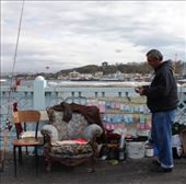 A lone fisherman is at home fishing on the Galata Bridge in Istanbul. Accompanied with a plush antique chair where he has laid his jacket, the fisherman baites his hook. During the autumnal period dozens if not hundreds gather on the bridge over the Bosphorus river as migratory fish head for warmer waters in the Aegean sea.: by sarahg, Views[279]
