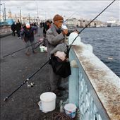 This fisherman has wrapped up warm for a long day holding his line. Accompanied by a deep bucket for his catch his aim is to fill it with migrating fish in the Bosphorus River.: by sarahg, Views[136]