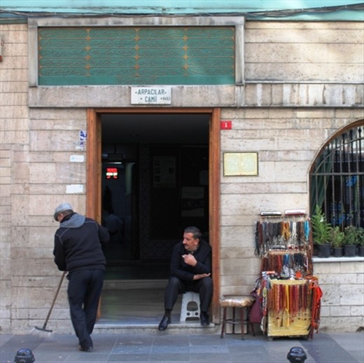 A street seller relaxes over a cigarette in the town. Traditional items such as prayer beads are sold mainly to tourists.