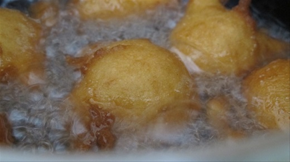 Frying the doughnuts.