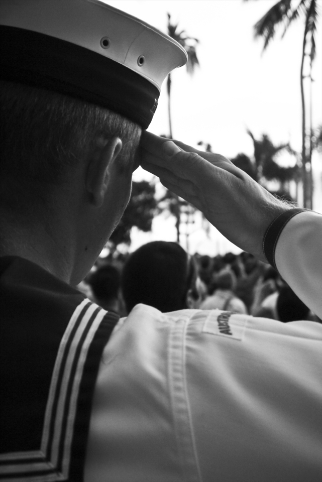 An ABLE Seaman salutes the Australian flag over the crowd as he stands proud during the ANZAC day ceremony held every year in front of the mini war memorial based on the beautiful esplanade of the renowned navy town of cairns. 
