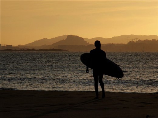 Surfer watching the sunset in Spain