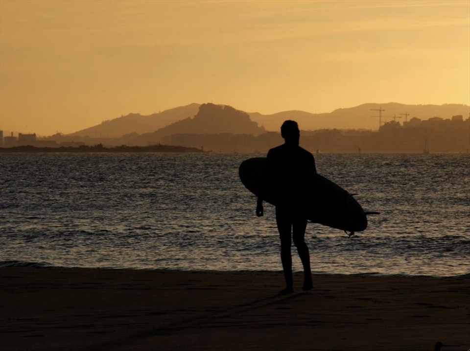 Surfer watching the sunset in Spain