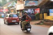 A women's pleasant and serene nature shining while she rides, side-straddle on the back of a motorbike, without protection, on India's notorious roads, Goa, India.: by sashaingoa, Views[541]
