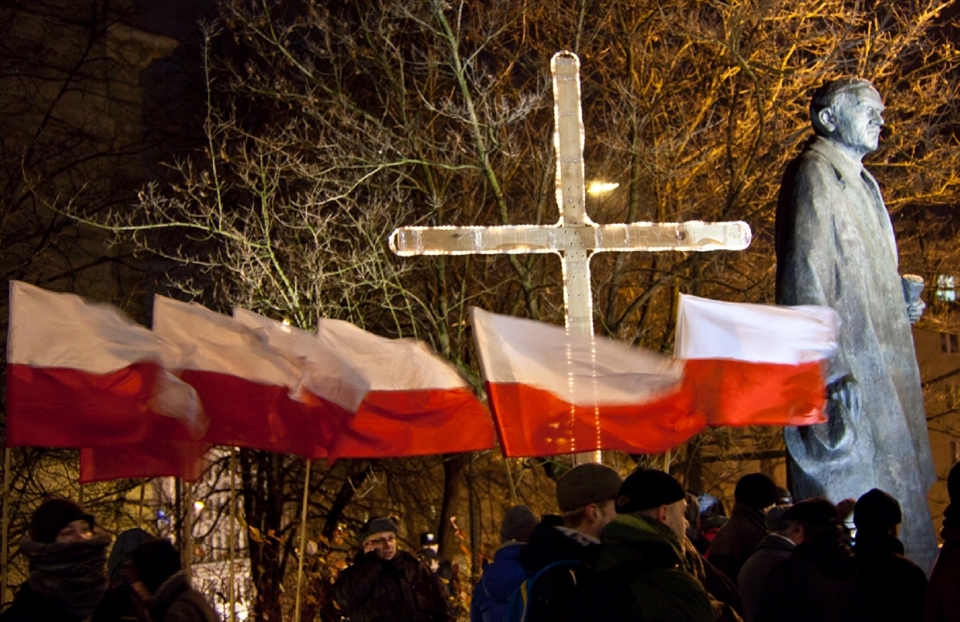 The statue of political activist Roman Dmowski, one of Poland's national heroes. Together with General Pilsudski he helped Poland gain independence from Russia, Prussia and Austria in 1918. Pictured here with a line of Polish flags and the Catholic cross, symbols important to the Polish nation.