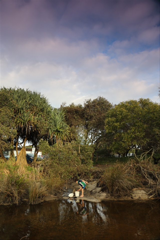 A boy digging sand for gold, as I was digging places for images.