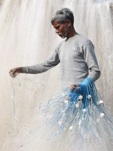 This fisherman from my village Sonpur is actually arranging his fishnet before h