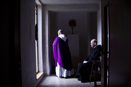 A monk bows his head as the Abbot walks into the oratory