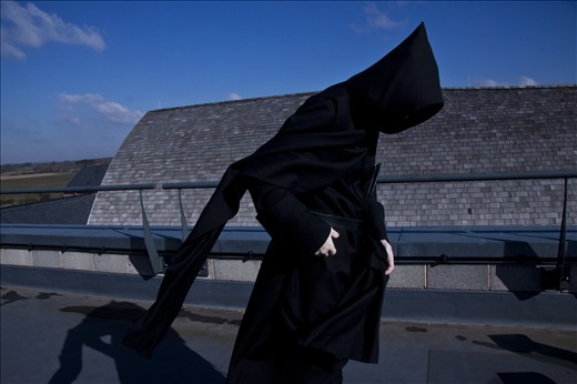 A monk leans into the wind during 