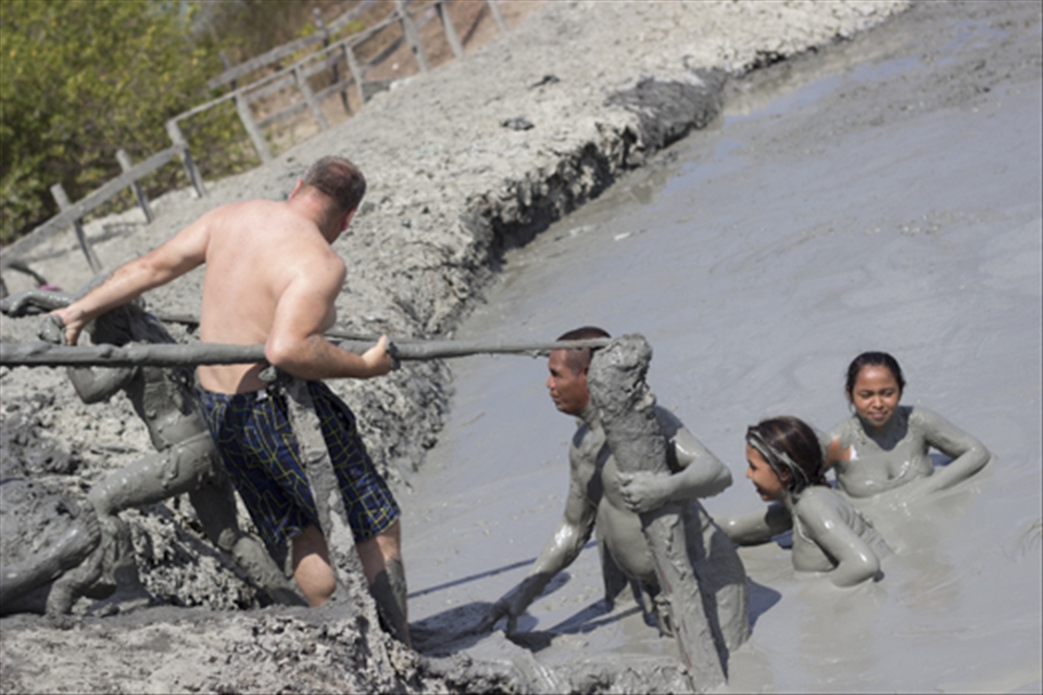 Getting in and out of the mud volcano. Mud is heavy, some people will help you.