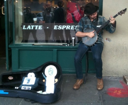 Music fills the air as people bustle around the first Starbuck's store and Pike Place Market. 