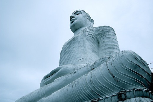 A seated Buddha almosts blends into the ether.