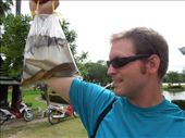 We came to a pond where a woman was selling baggies containing 1 of each: a frog, fish, and eel. Joe buys a bag.: by sglass, Views[147]