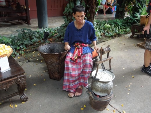 Man demonstrating the process of silk-making