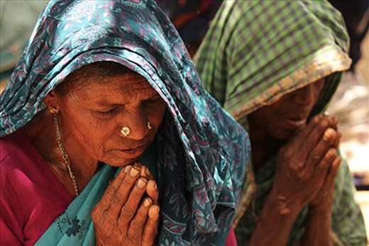 Two of the village's older residents kneel to pray before a meal one afternoon. Though beliefs vary from village to village, faith is an important part of villagers' daily lives. With problems such as little access to basic medical care and frequent water shortages, the villagers often rely on prayer and their faith to help them work through these difficult situations.