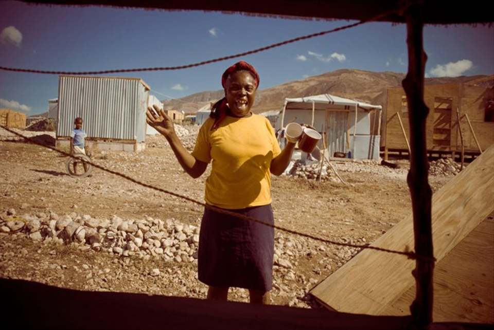 A lady gets cups ready to serve coffee to her friends helping her rebuild.