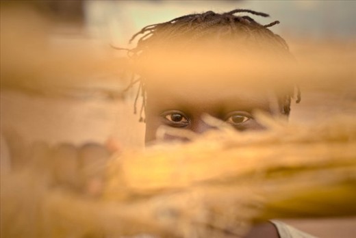 A young girl looks through the remains of her home after the earthquake in Haiti