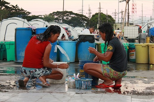 Because water is barely accessible the community’s small improvised bathroom, these ladies took a bath on where water is most likely accessible—beside pails of water. Those stockpiles of large pails of water are just a part of 8 tanks of water delivered by the firemen that day.