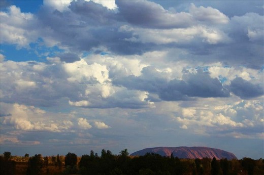 This photo was taken from the view of my hotel room as Ayers Rock caught the last glimpse of sun setting over her body. The peaceful ambiance and serene silence echoed throughout the remote outback. The only sound you could hear was the pounding heart beat of the mighty formation flowing blood through Australia's earth as magic and wonderment filled the air.  
