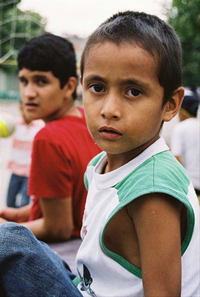 Neighborhood children take a break from the volleyball game, for a stranger with a camera.