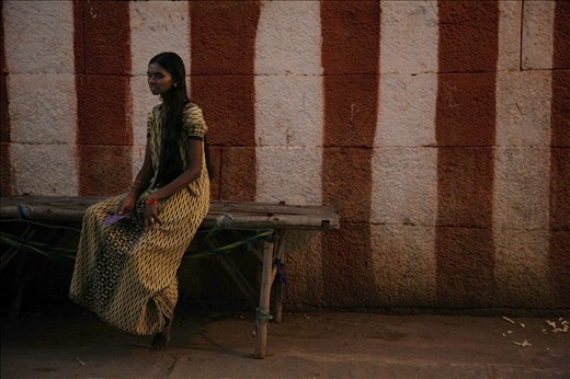 Grace and Poise...


When I passed this girl I had an initial desire to look over my shoulder for someone photographing her. Her poise and grace was nothing short of a trained professional and yet she sat, engaged in nothing but the thoughts of her own reality. Was she one of the luckier ones? The Karnataka region is home to thousands of Devadasi women. A religious custom that originally gave Devadasi women status and yet over the centuries has deteriorated to a life of prostitution and the fear of HIV. For many, children as young as 12 are introduced to the industry in order to support their family. 