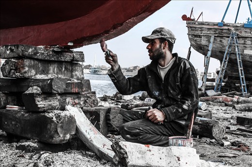 a man painting a boat in ezbet al-burg 
