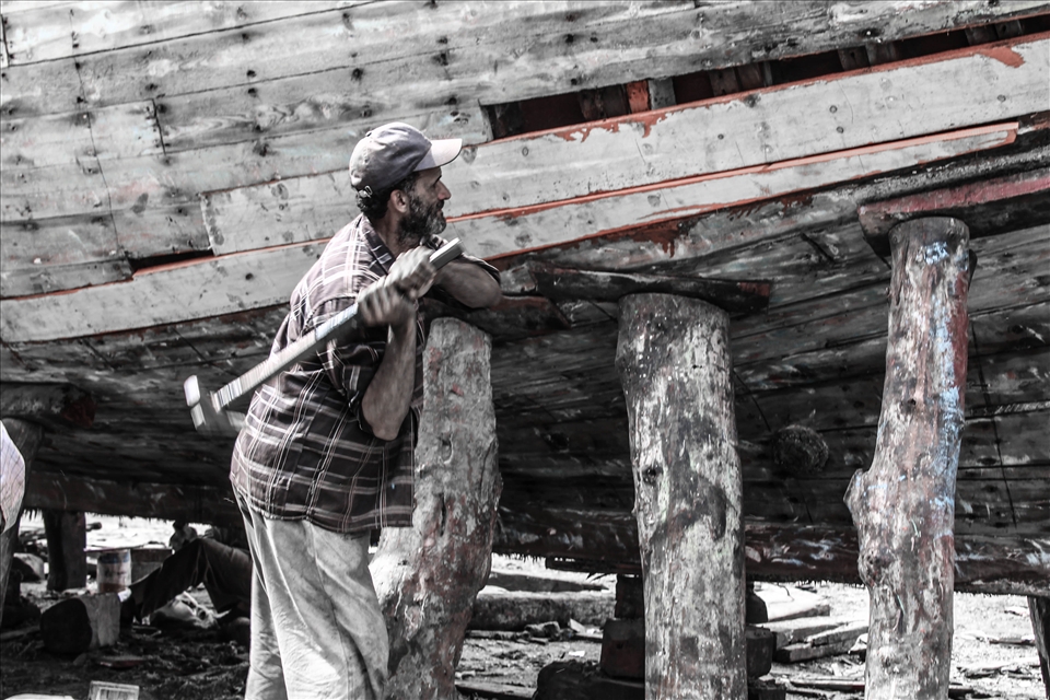 a man fixing a boat in ezbet al-burg