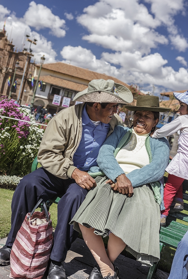 A couple enjoy the day at the Plaza de Armas with their daughter during Cusco Carnival or Cusco Week, when there are daily processions in the Plaza de Armas, the central plaza in historic Cusco.  