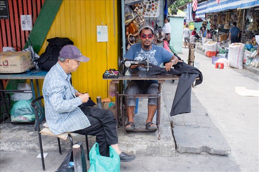 A street tailor operating a ‘while you wait’ alteration service.  Kota Kinabalu - Borneo, Malaysia.