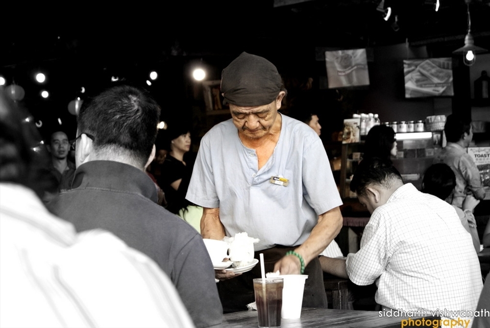 A seemingly 80+ year old man waiting a table at a local coffee shop at Vivo City, Singapore. The man and many other elderly folk like him in Singapore symbolize the undying spirit of the city