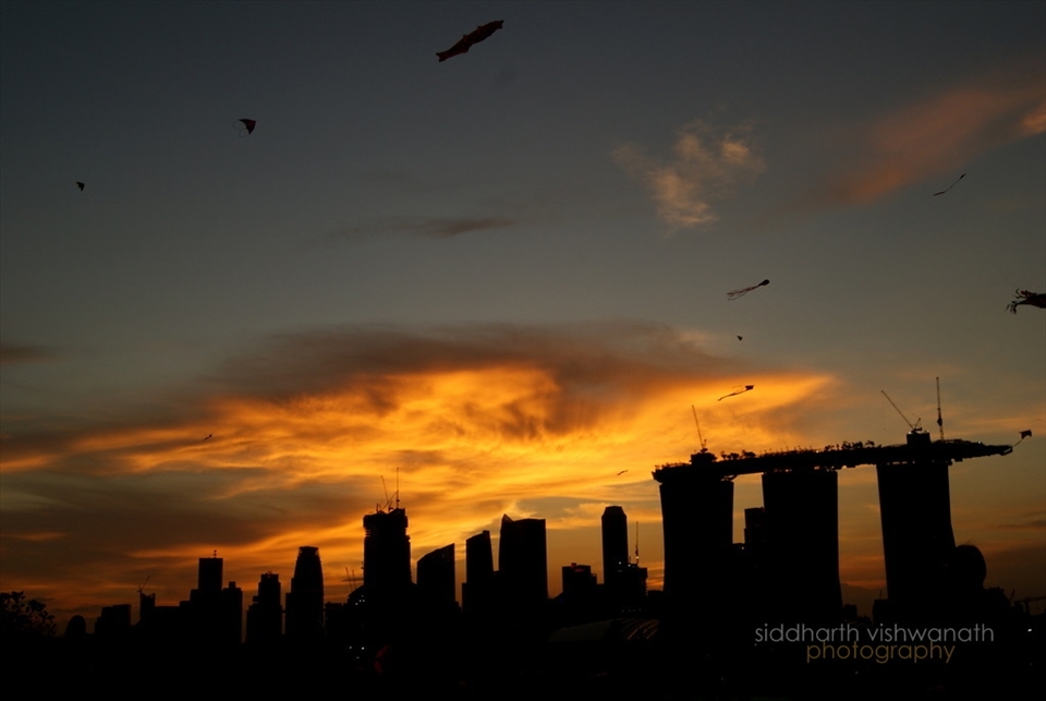 A kite flying day at the Marina Barrage, Singapore overseeing the Singapore skyline. The golden clouds look like a giant kite in the sky itself
