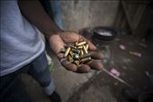 A gang member in Kingston, Jamaica holds a handful of bullets in his backyard.: by silveydustin, Views[269]