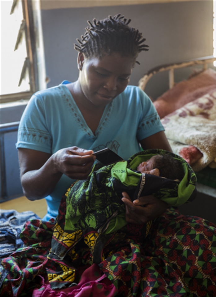 We visited the Mbamba Village Hospital where the doctor there showed us the room where mothers were recovering with their newborn babies. I had brought an instant camera with me for this purpose - I took family portraits of each mother with their baby and gave them their photos. Here is one mother watching as her life moment begins to appear on an instant photo.