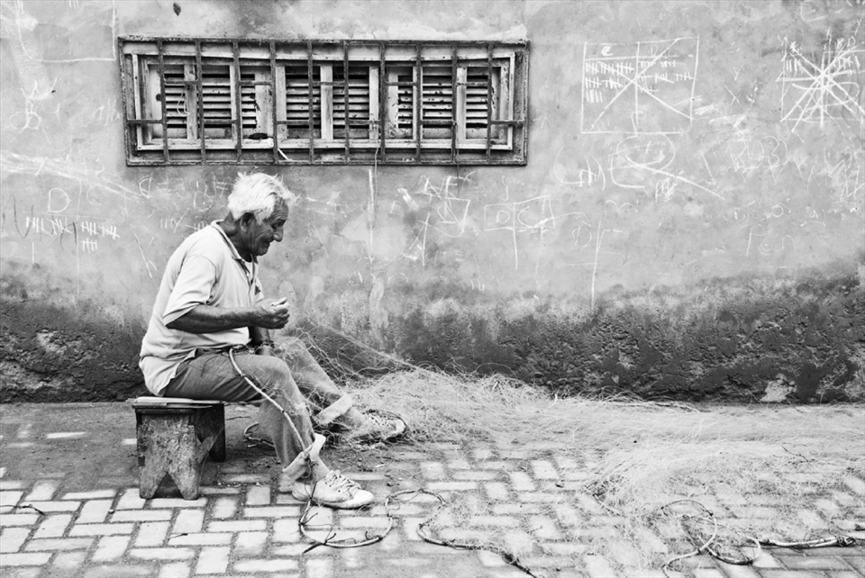 A fisherman fixing his net before going back to the sea.
