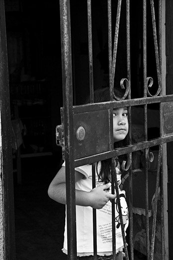 Little girl looking through her front door in Huanchaco.