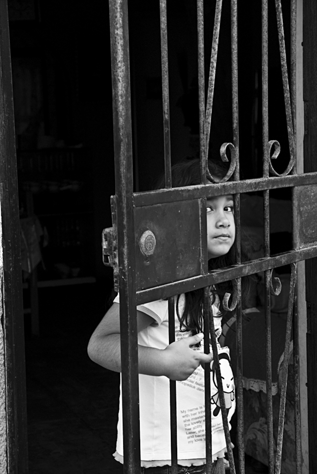 Little girl looking through her front door in Huanchaco.