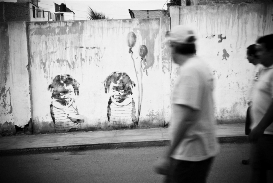 Locals in Huanchaco walking by a gruesome yet artsy graffiti.