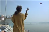 A young girl in mended jumper flies her kite peacefully over the Ganges: by simonhansen, Views[105]