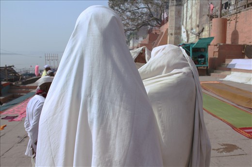 Two men draped in laundry have a discussion 