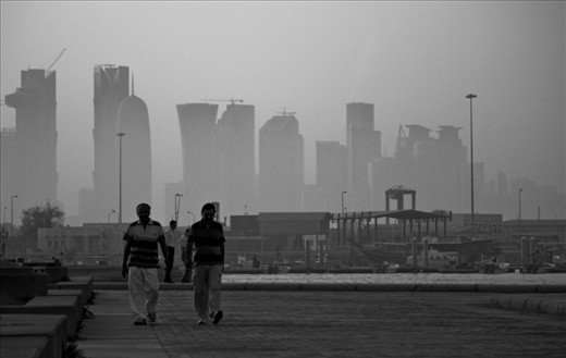 With only around 200,000 Qataris, the majority of the country is built, run and maintaned by migrant workers from all over the world. Two indian workers who have come to earn money to support their families at home take an afternoon stroll along the Corniche despite the extreme heat and humidity