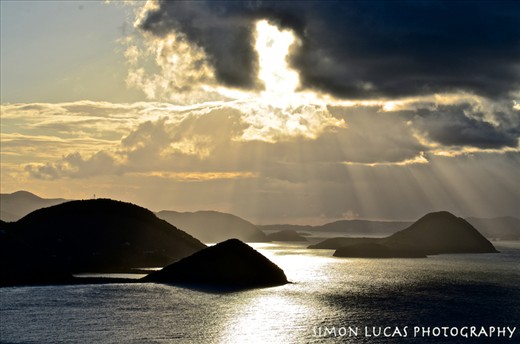 Sun kissed islands. To be honest I wasn't expecting the British Virgin Islands to be so mountainous. They rise steeply out of the depths to around 1700 feet. Consequentially it offers great hiking and amazing ocean views. This is the view looking west towards Great Thatch Island from above Cane Garden Bay. I chose this photo because of the great combination of light and color but it also gives the viewer insight to the local topography and the many small islands dotted around the area.