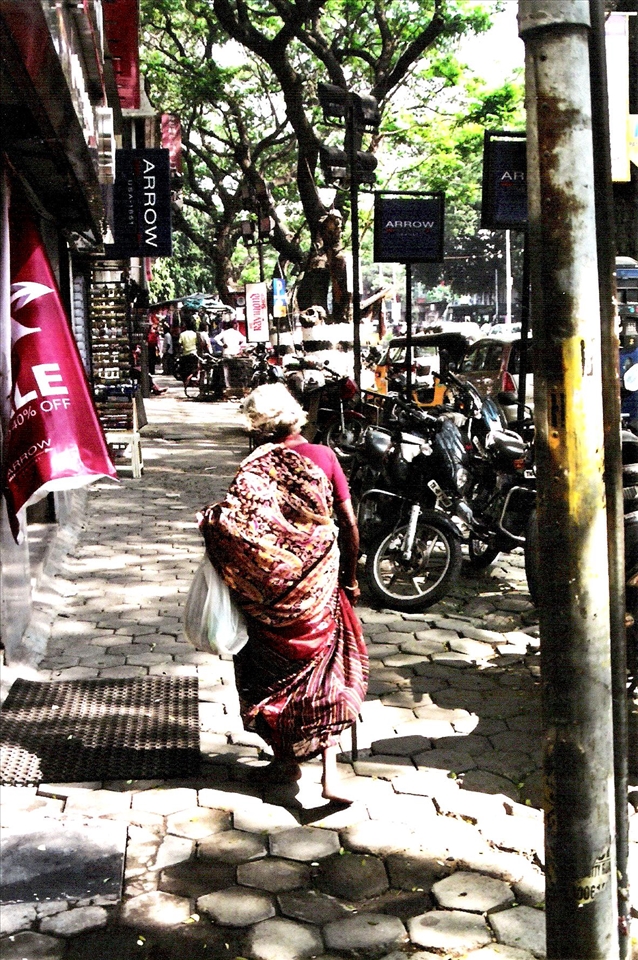 Bare feet, plastic bag and a wooden stick acts as her only support