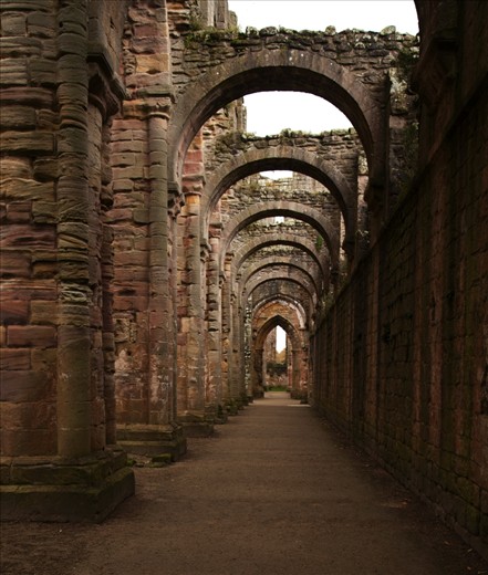 Corridor in a rundown Abbey. The archways draws your eyes all the way through.