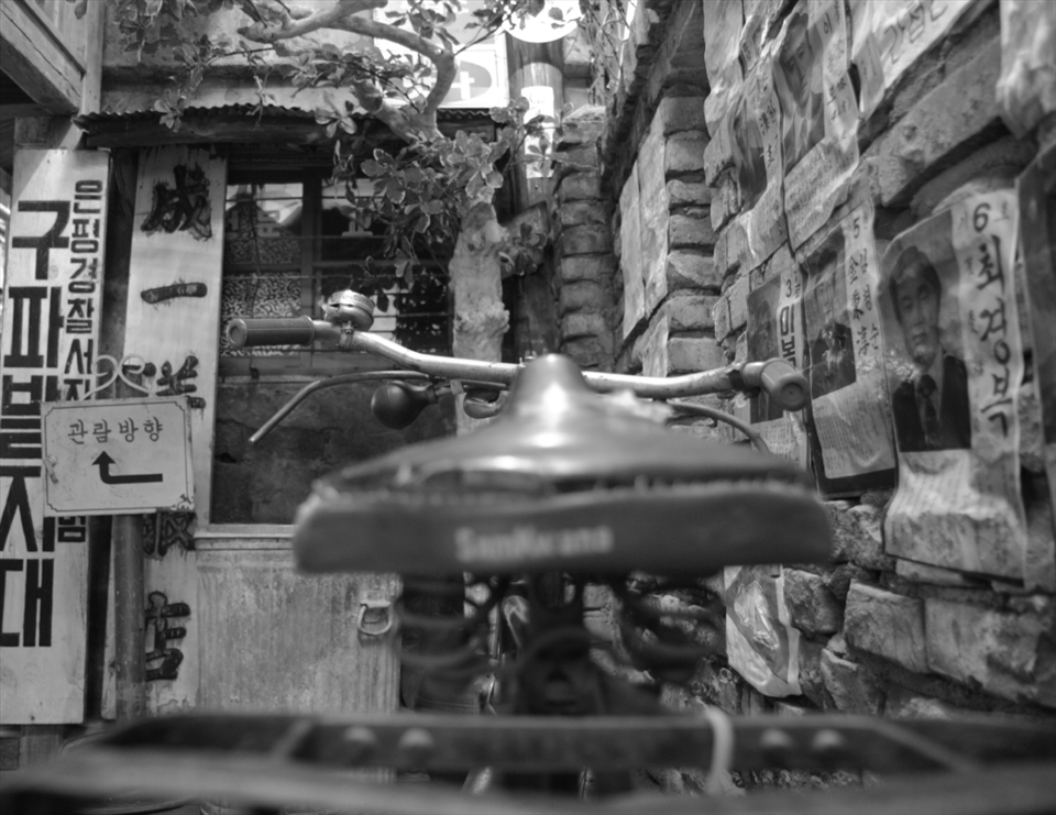 The best bicycles have storage racks in the back - useful for transporting materials as well as dates. The bumpy roads helped with the romance; the passenger was often forced to cling tightly to the pedaler. In the developing cities of Korea, walls peppered with advertisements and political campaign posters were a common sight. 