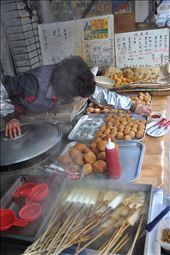 Respite in the Street.  From early morning to late in the evening, this grandma reaches over to serve, skewers fish cakes, rolls mochi, washes cups, keeps the boilers and fryers fired up and filled with comfort food cooking, all in about 60square feet of cosmic rhythm with passersby combating the cold weather. (Gimhae, South Korea): by skyladyluck, Views[485]