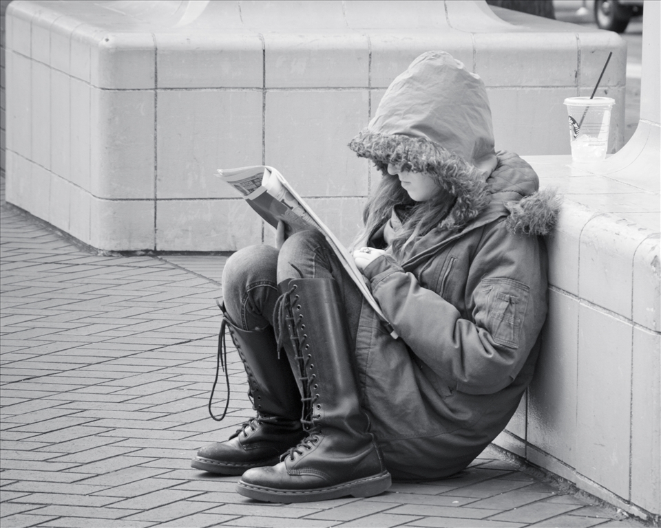 Reading the newspaper on the street. 