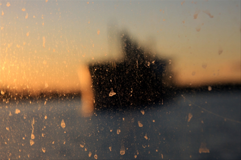 Beautiful shape of a boat through a dirty window. Can you see something else?